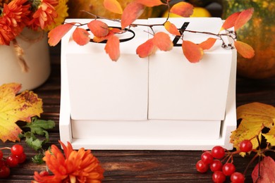 Photo of Thanksgiving day, holiday celebrated every fourth Thursday in November. Block calendar and autumn leaves on wooden table, closeup