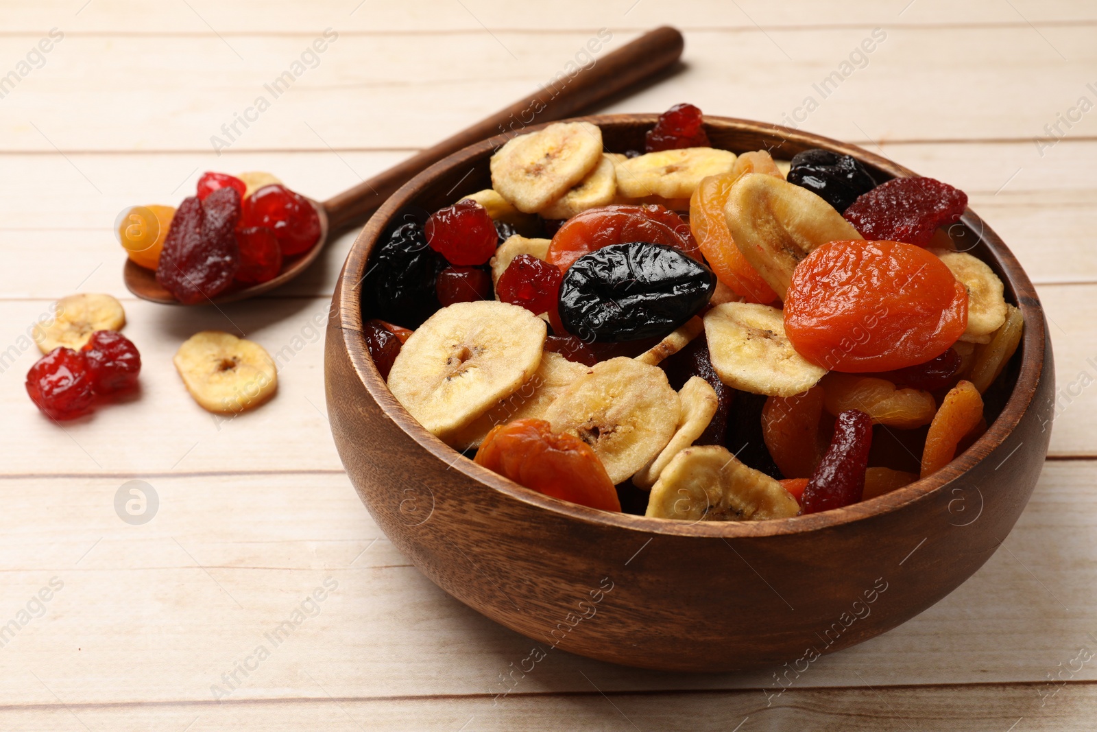 Photo of Mix of delicious dried fruits on white wooden table, closeup