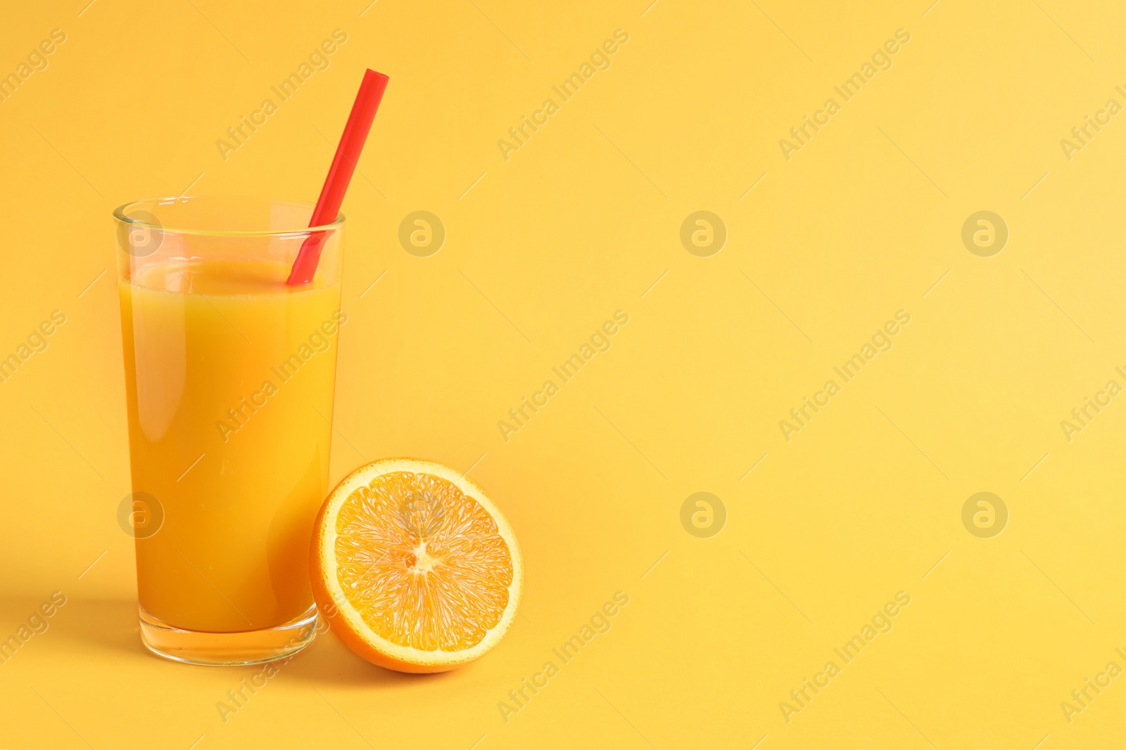 Photo of Glass of orange juice with fresh fruit on color background