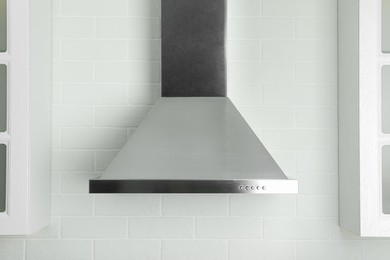 Photo of Modern range hood on white brick wall in kitchen