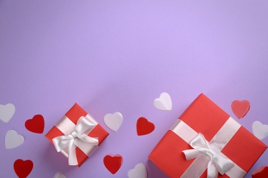 Photo of Gift boxes and hearts on violet background, flat lay with space for text. Valentine's Day celebration