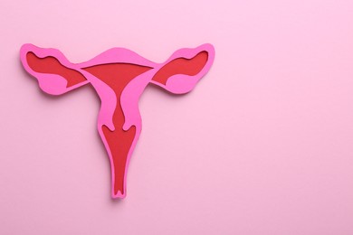 Reproductive medicine. Paper uterus on pink background, top view with space for text