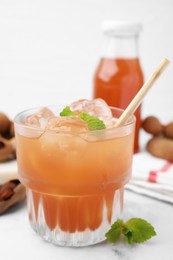 Photo of Freshly made tamarind juice with mint on white table, closeup. Space for text