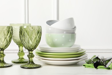 Photo of Beautiful ceramic dishware, glasses and cutlery on white table