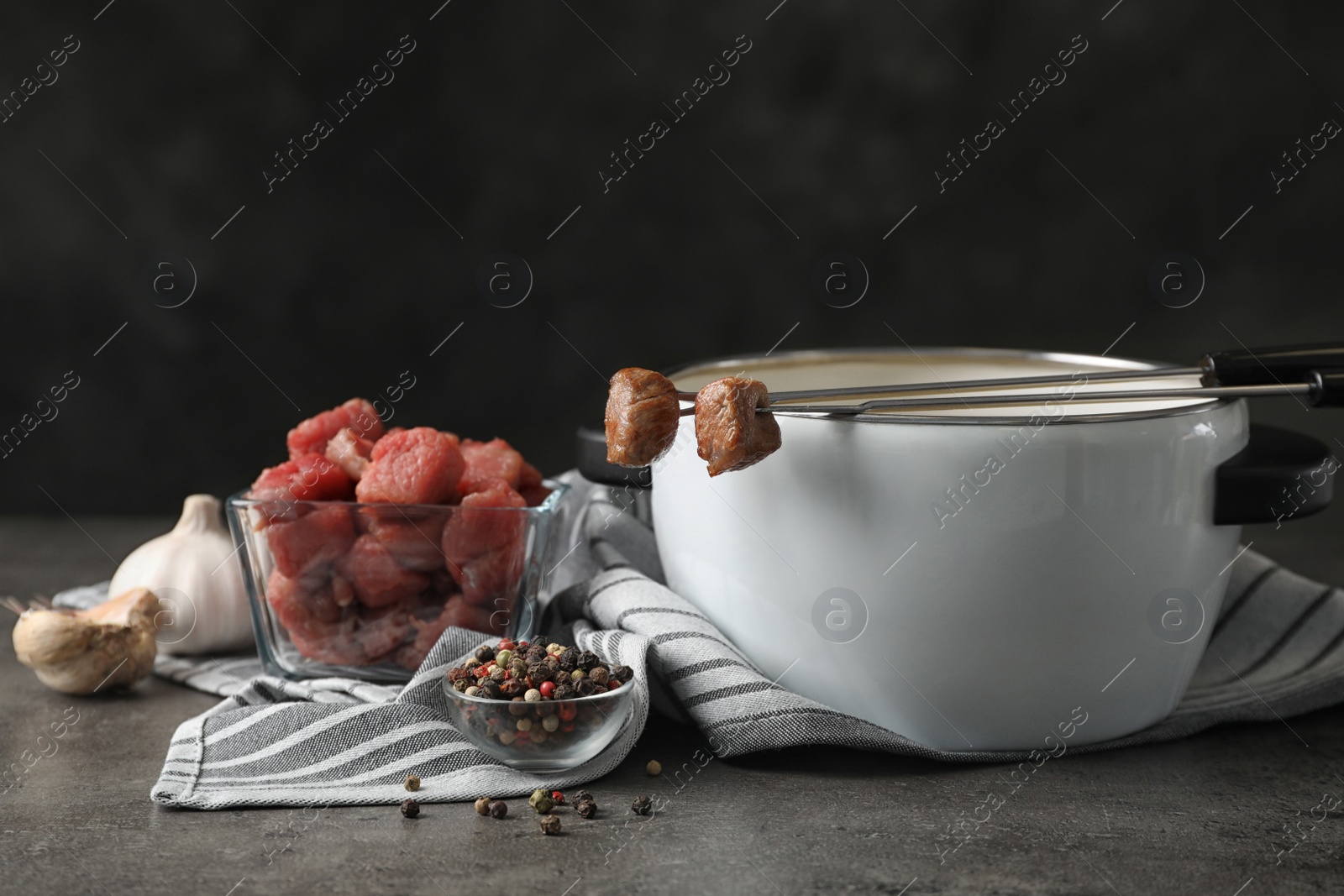 Photo of Composition with fondue pot and meat on table