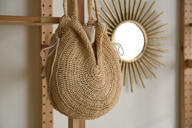 Photo of Stylish woman's bag hanging on rack in boutique