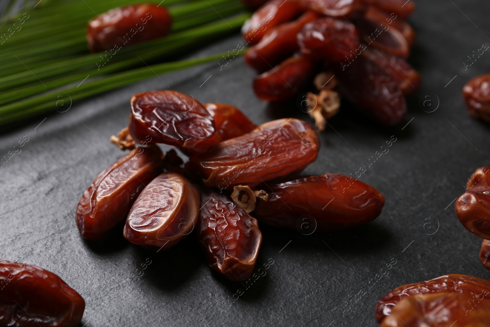 Photo of Tasty sweet dried dates on black table, closeup