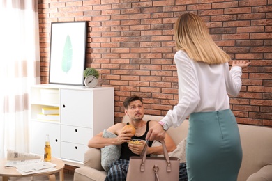 Lazy husband quarrelling with hardworking wife at home