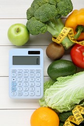 Calculator and food products on white wooden table, flat lay. Weight loss concept