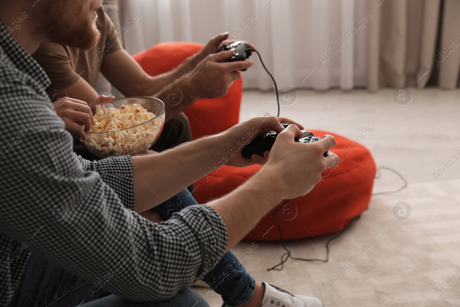 Photo of Group of friends playing video games at home, closeup