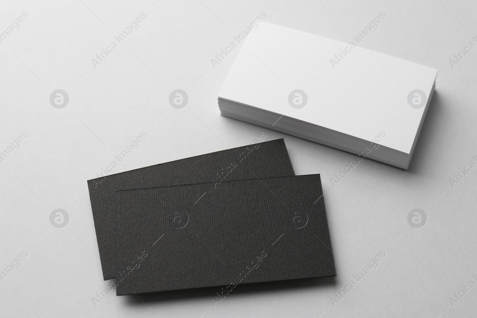 Photo of Blank black and white business cards on light background, above view. Mockup for design