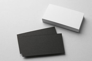 Blank black and white business cards on light background, above view. Mockup for design