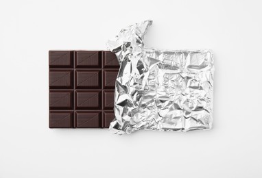 Tasty chocolate bar on white background, top view