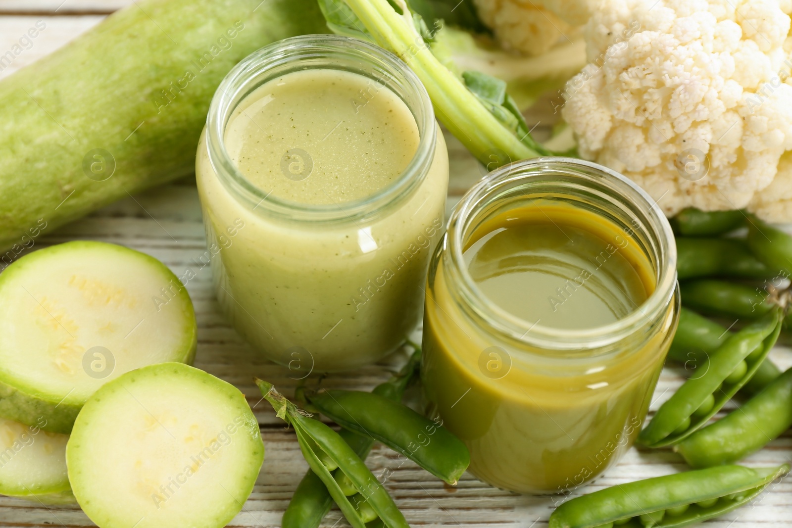 Photo of Jars with healthy baby food and ingredients on table