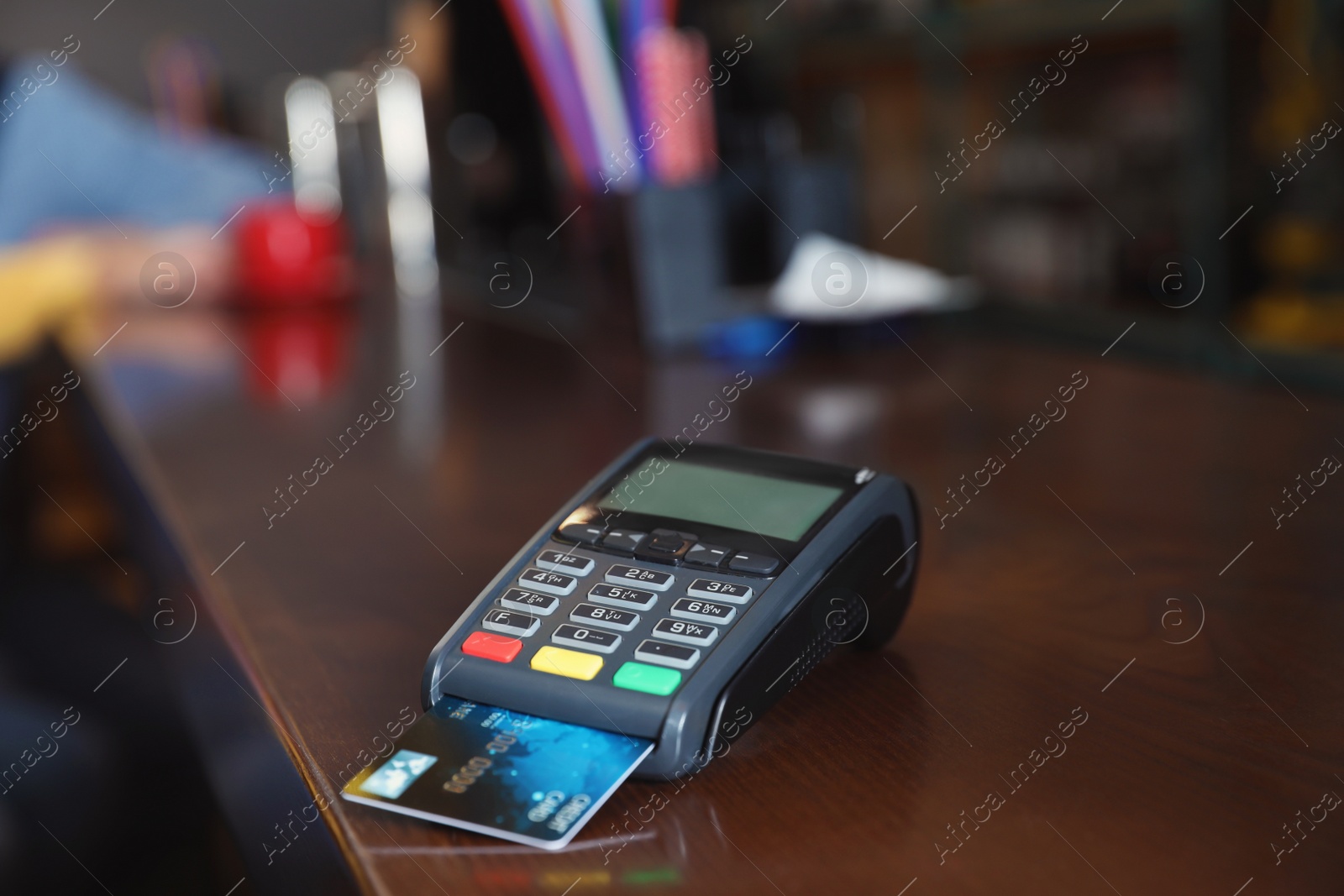 Photo of Credit card machine for non cash payment on wooden counter in cafe. Space for text