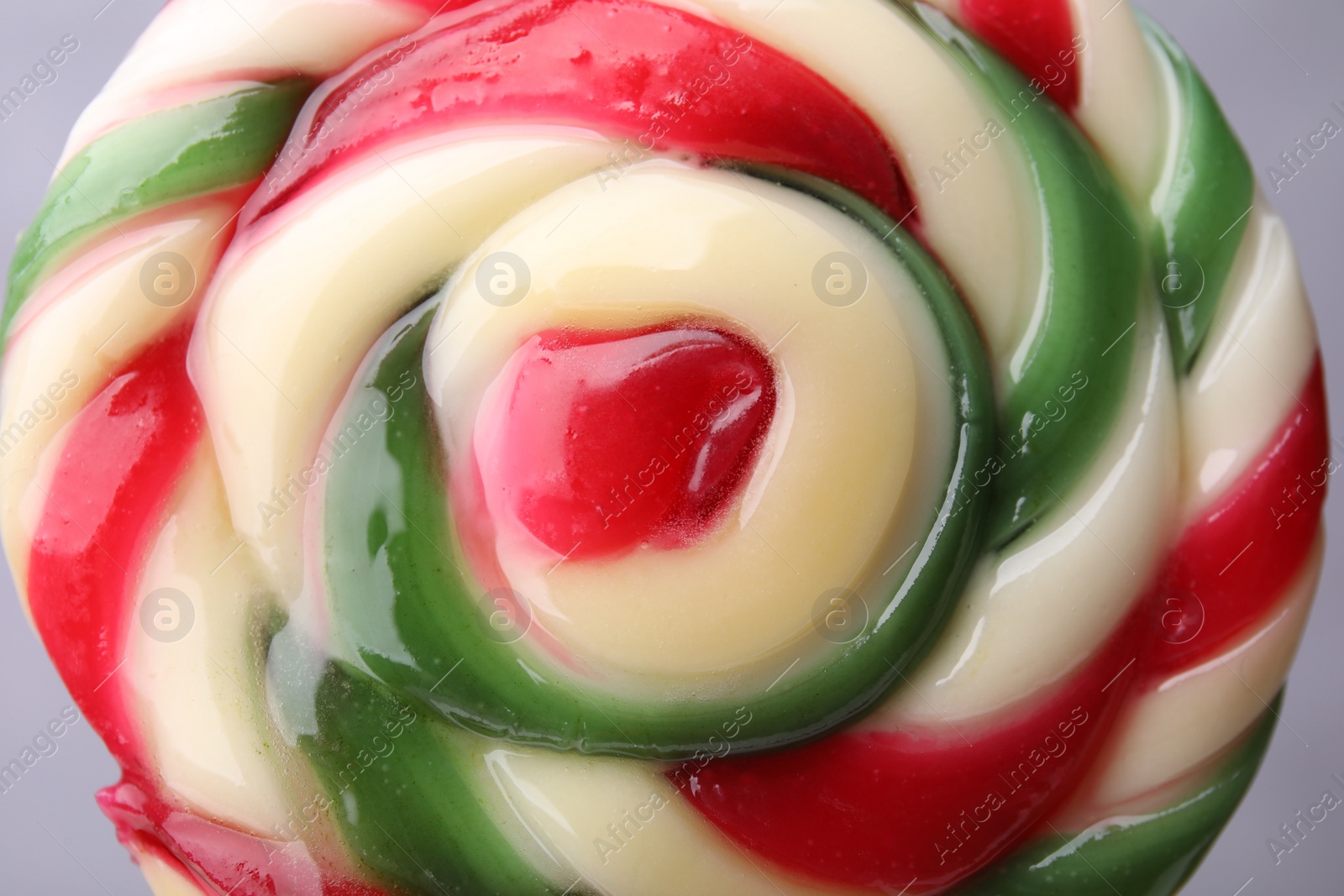 Photo of Colorful lollipop swirl on grey background, closeup