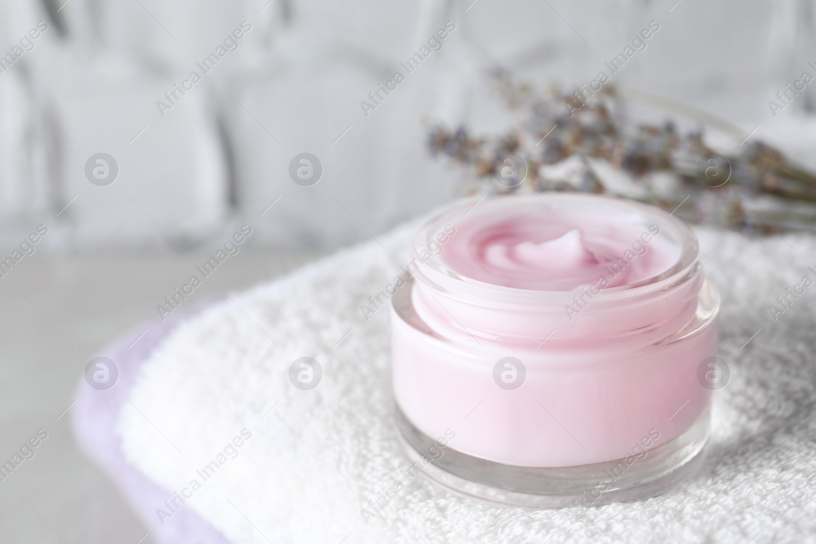 Photo of Open jar of cream on towel, closeup. Space for text