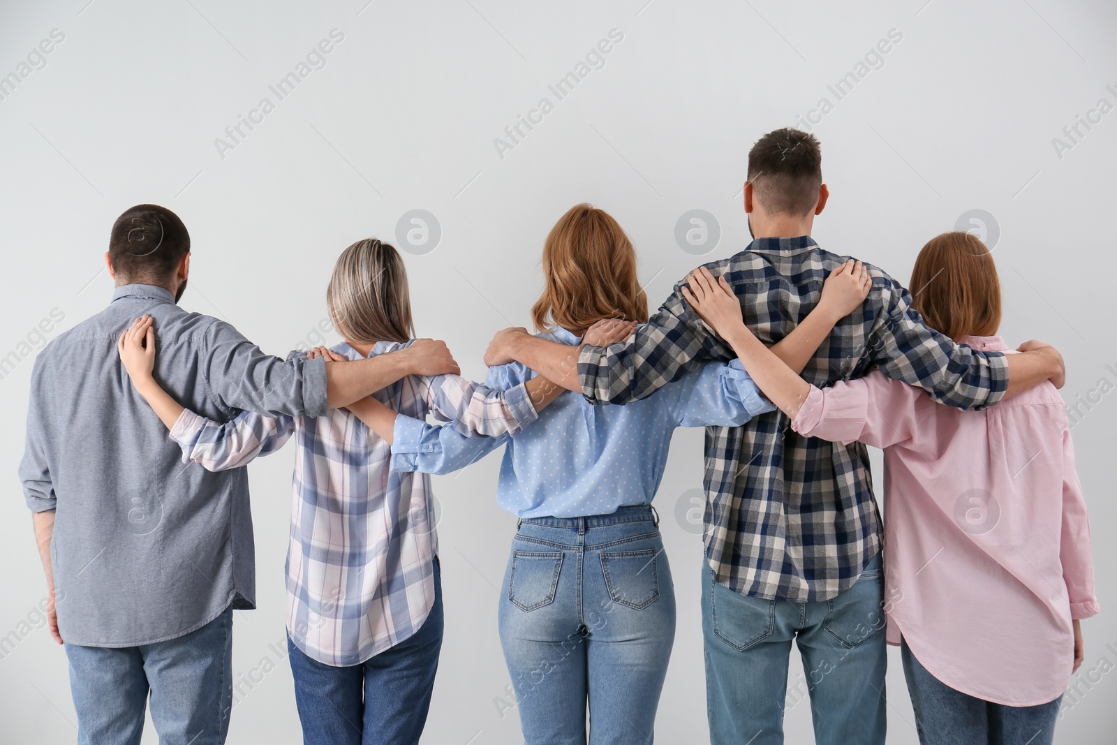 Photo of People hugging together on grey background, back view