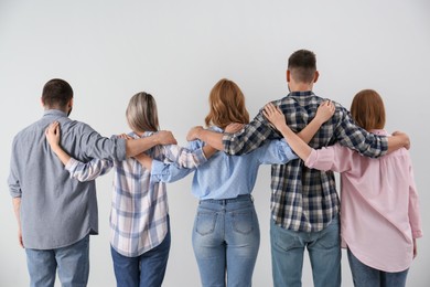 Photo of People hugging together on grey background, back view