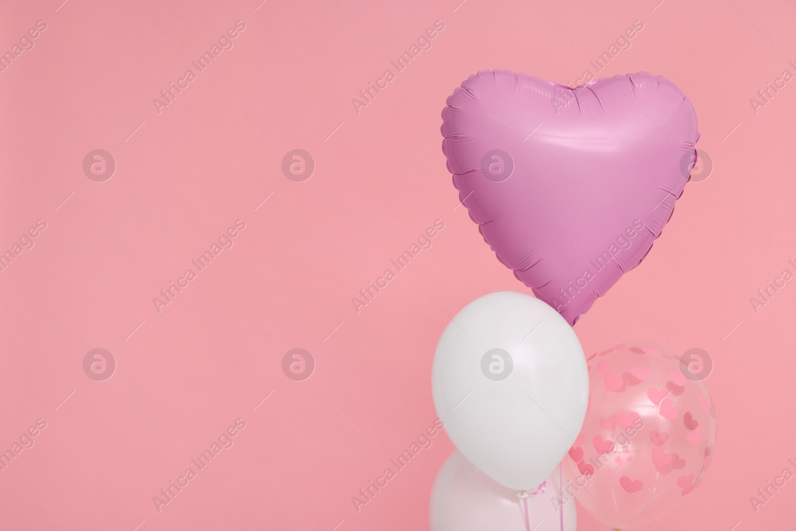 Photo of Bunch of heart and round shaped balloons on pink background, space for text. Birthday party