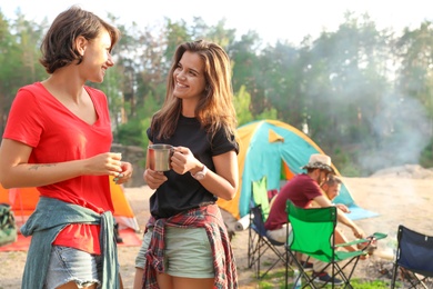 Photo of Young women near camping tent in wilderness