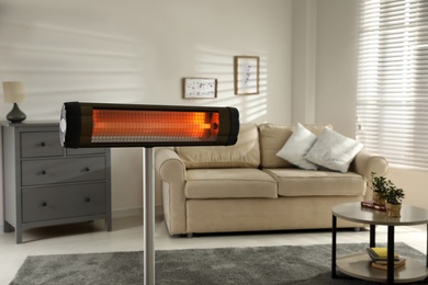 Photo of Modern electric infrared heater in living room