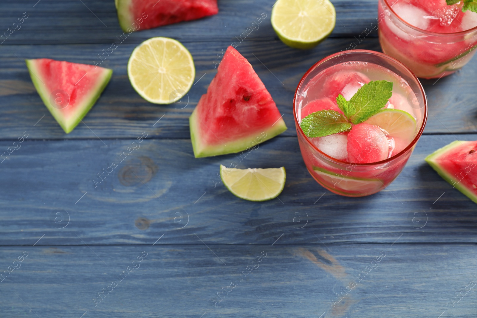 Photo of Delicious refreshing watermelon drink on blue wooden table, above view