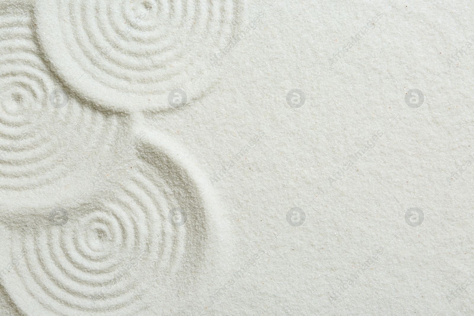 Photo of Zen rock garden. Circle patterns on white sand, top view. Space for text