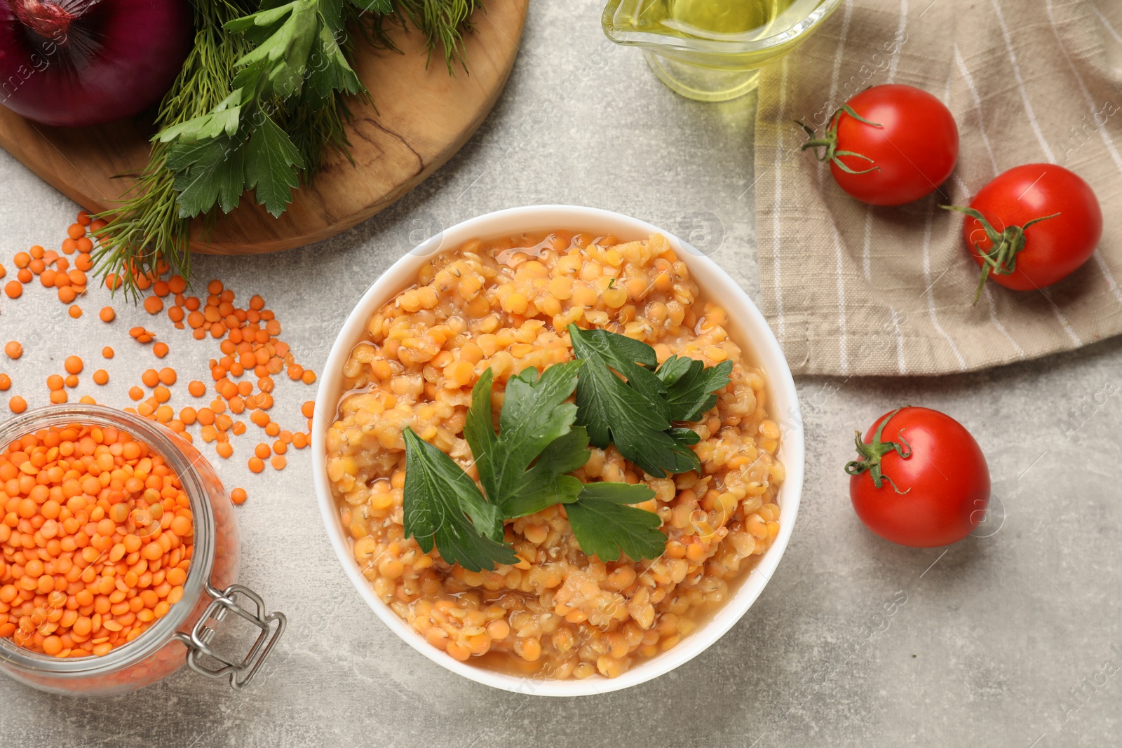 Photo of Delicious red lentils and products on light grey table, flat lay