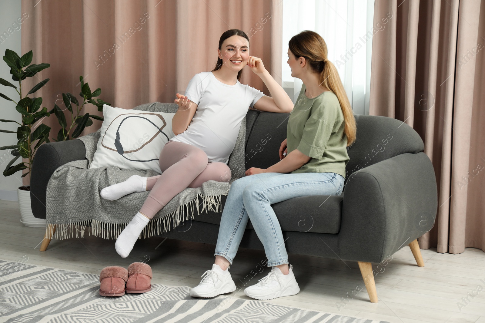 Photo of Doula working with pregnant woman on sofa at home. Preparation for child birth