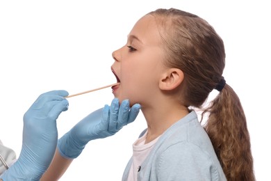 Doctor examining girl`s oral cavity with tongue depressor on white background