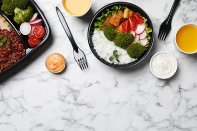 Flat lay composition with healthy takeaway food on white marble table. Space for text