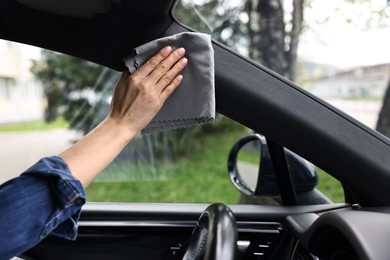 Photo of Woman wiping her modern car with rag, closeup