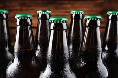 Many bottles of beer on wooden background, closeup