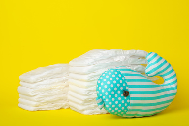 Photo of Diapers and toy whale on yellow background
