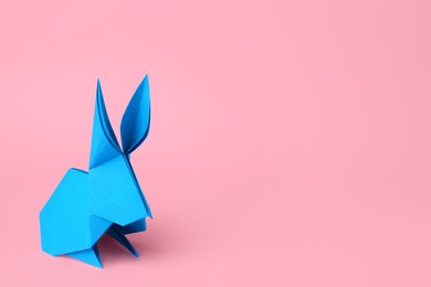 Origami art. Paper rabbit on pink background, space for text