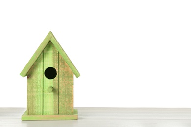 Beautiful green bird house on wooden table against white background, space for text