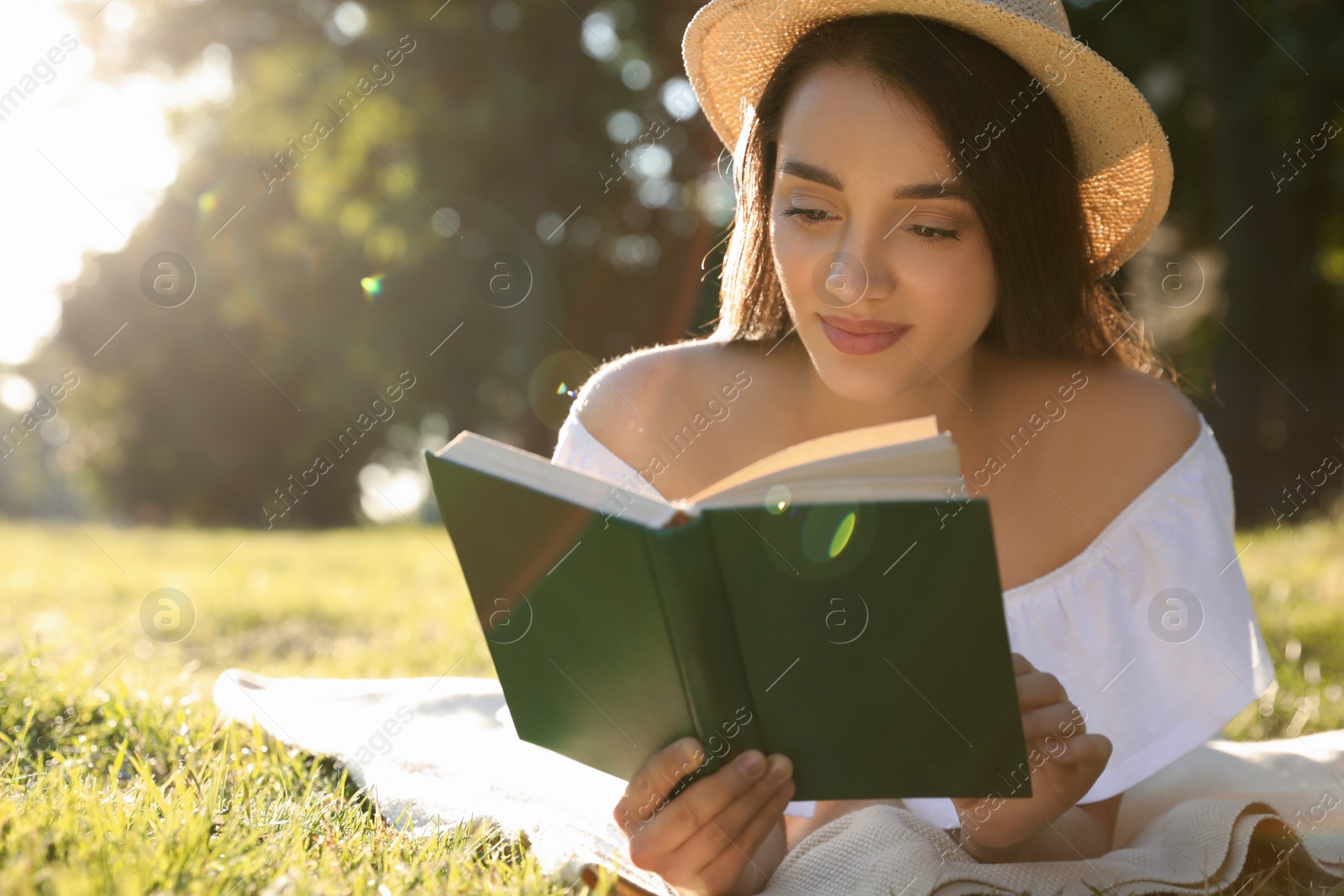 Photo of Beautiful young woman reading book in park