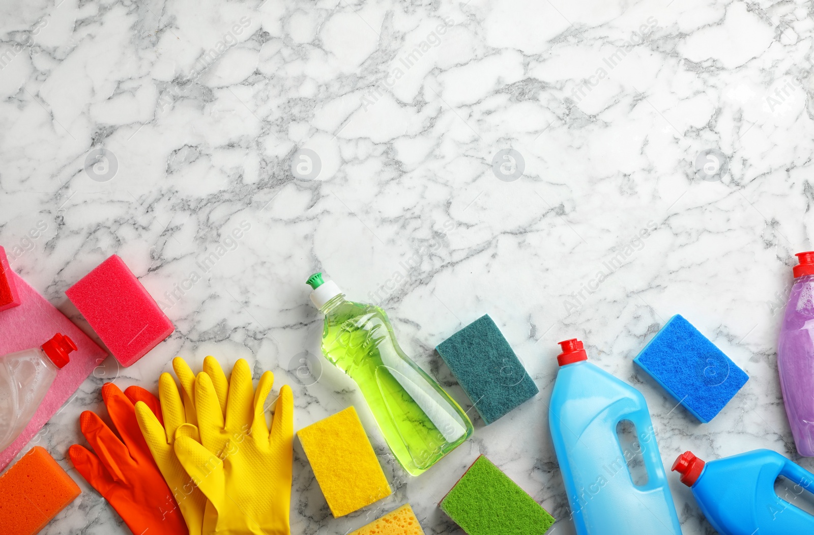 Photo of Flat lay composition with cleaning supplies for dish washing and space for text on marble background