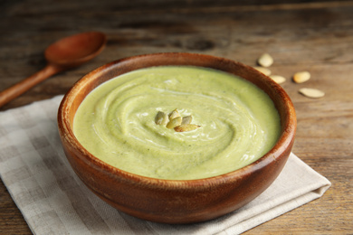 Photo of Delicious broccoli cream soup served on wooden table