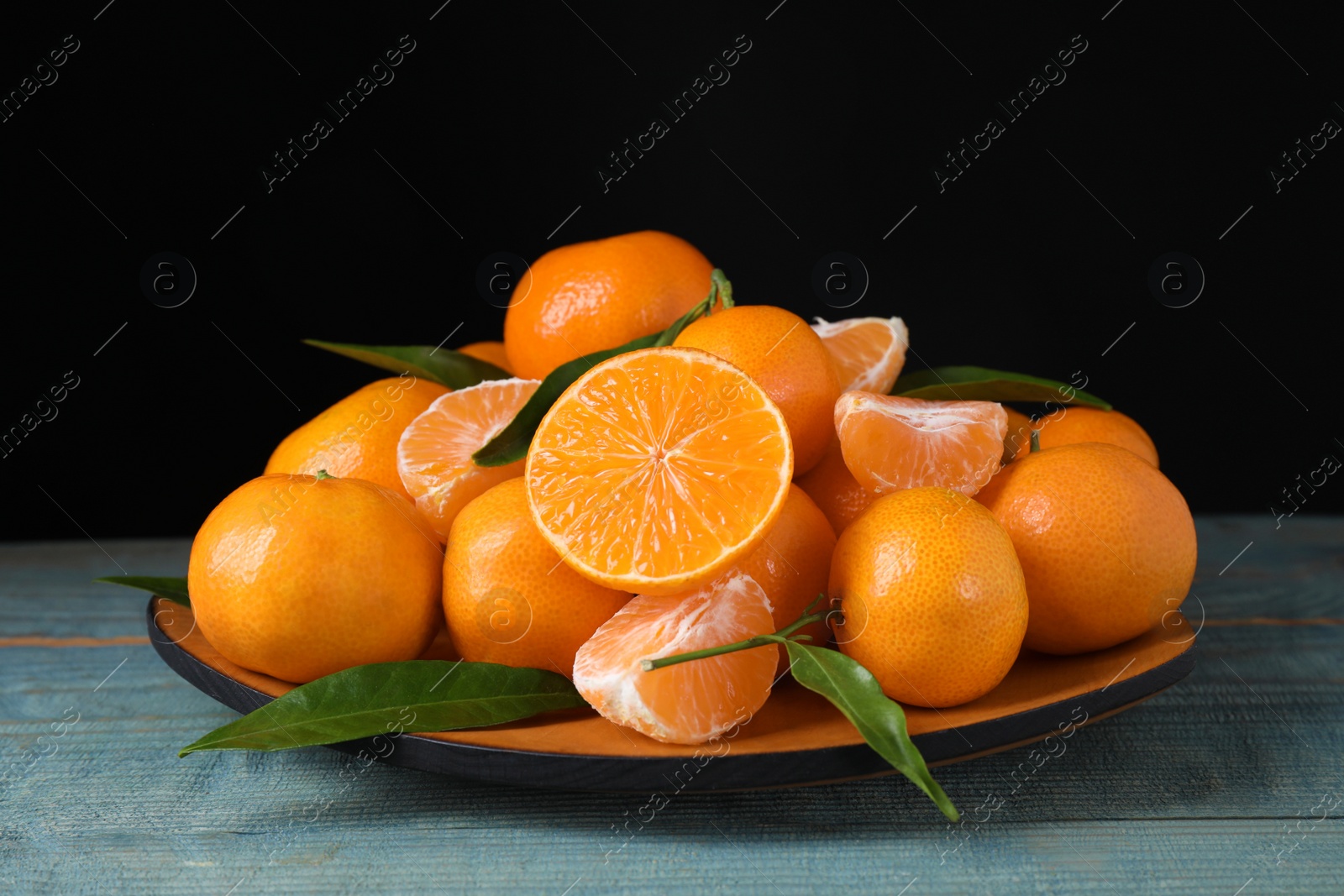 Photo of Fresh ripe tangerines on blue wooden table