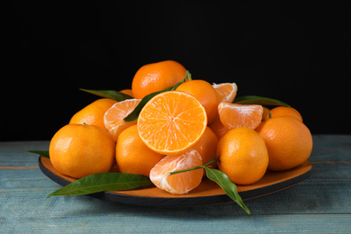Photo of Fresh ripe tangerines on blue wooden table