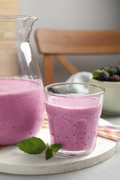 Delicious blackberry smoothie and mint on white table indoors