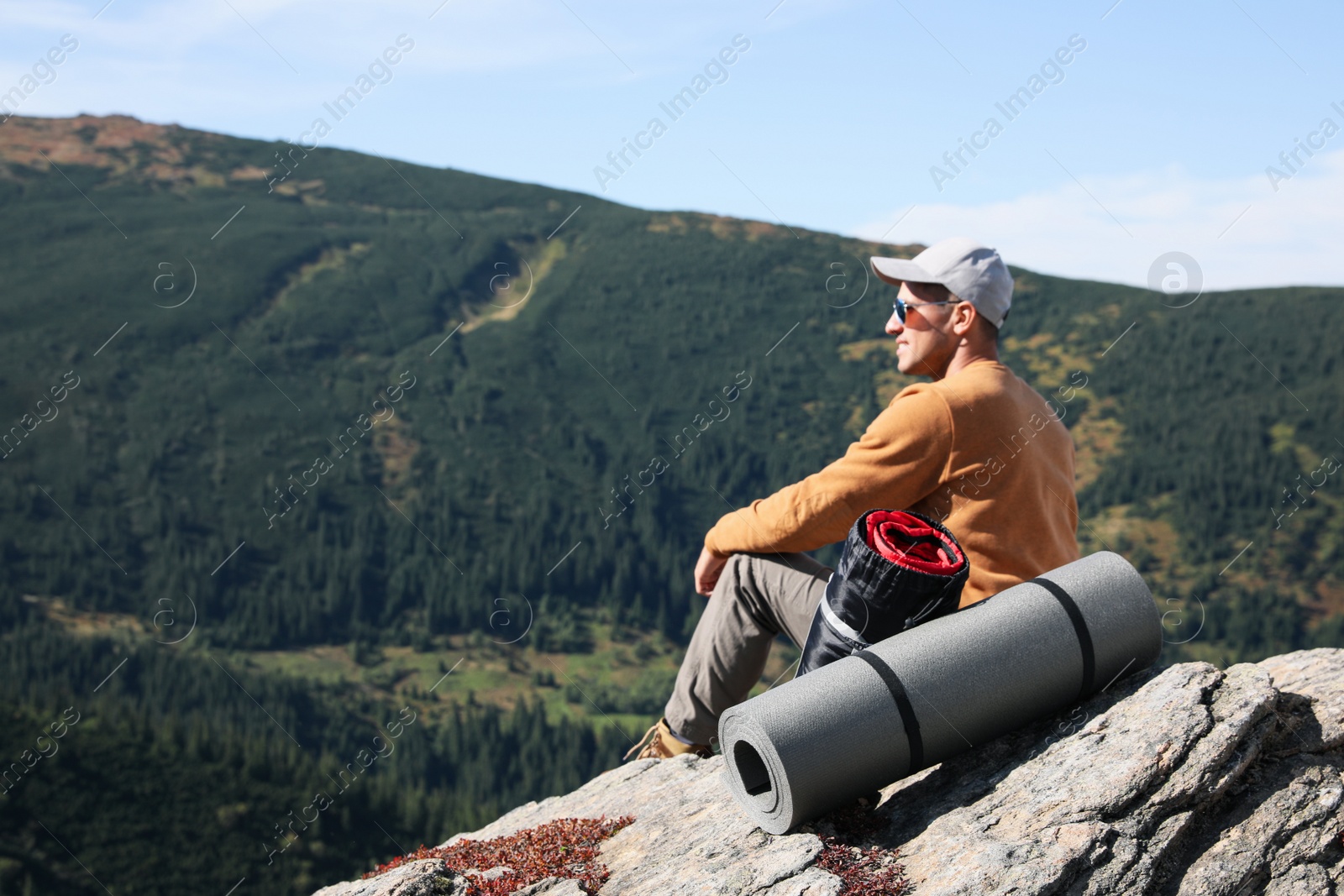 Photo of Tourist with sleeping bag and mat on mountain peak