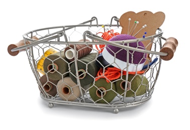 Photo of Basket with set of color sewing threads on white background