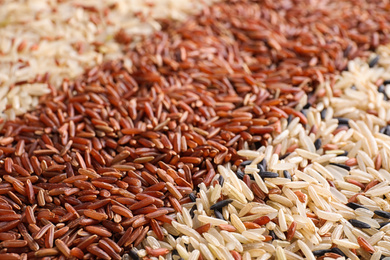 Photo of Mix of different brown rice as background, closeup