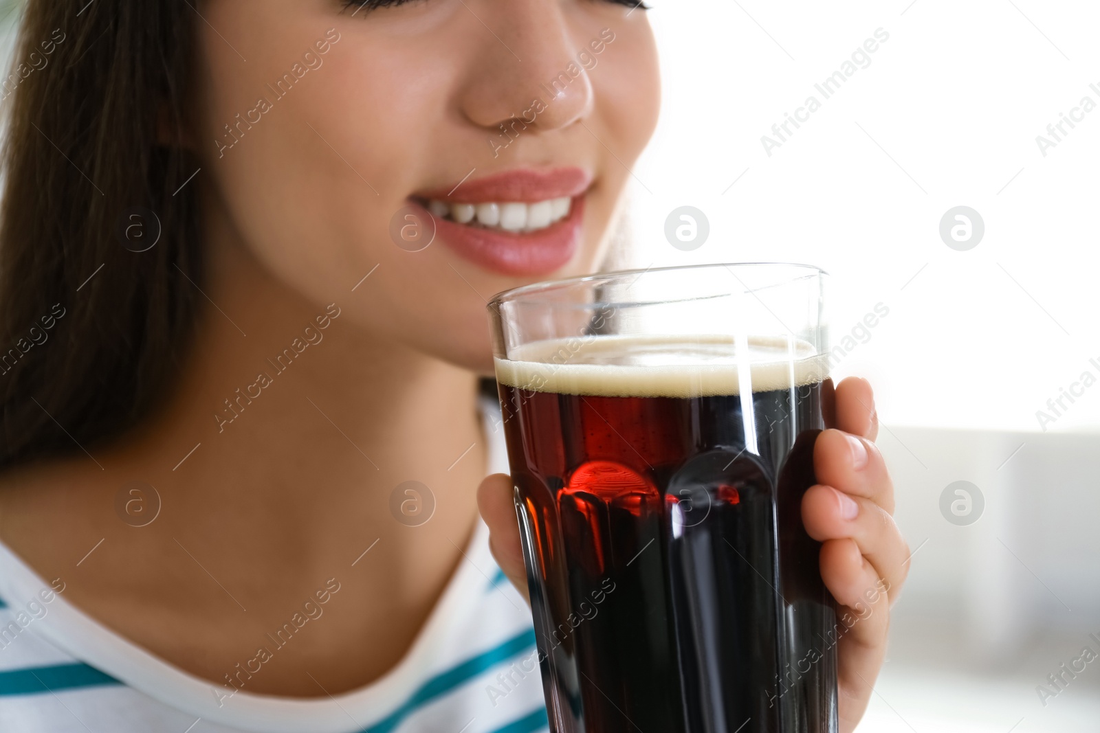 Photo of Young woman with cold kvass indoors, closeup. Traditional Russian summer drink