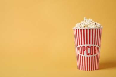 Photo of Delicious popcorn on yellow background. Space for text