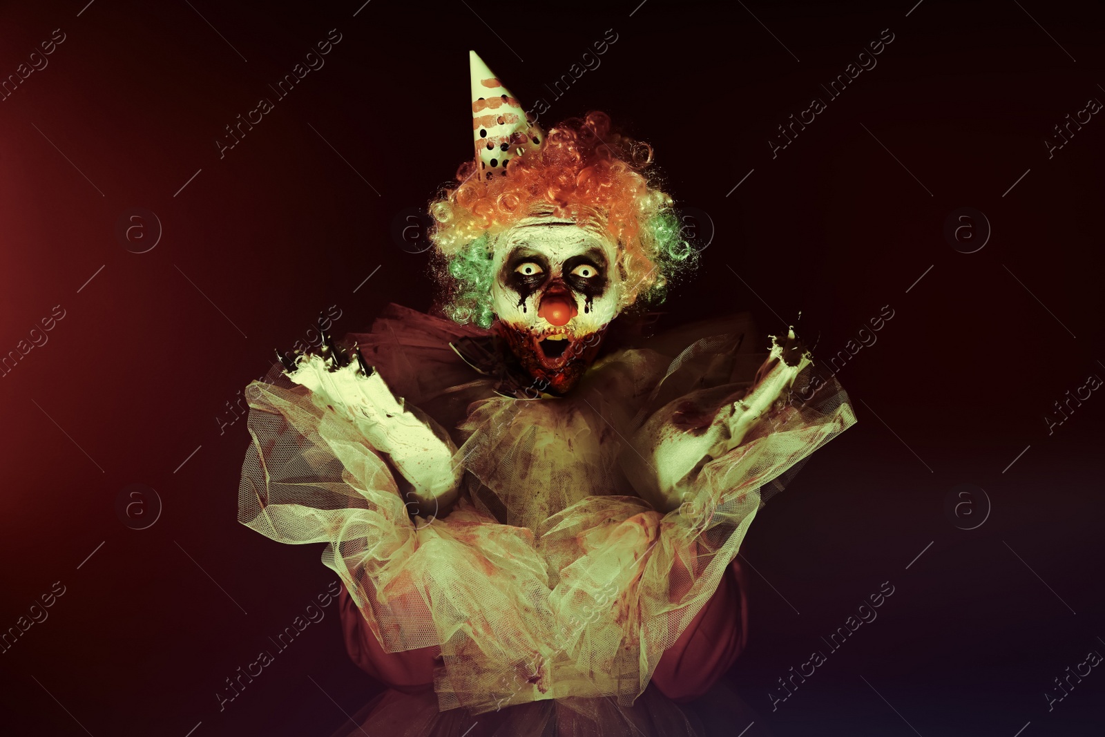 Photo of Terrifying clown in darkness. Halloween party costume