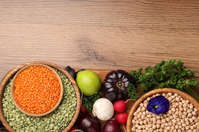 Photo of Different vegetables on wooden table, flat lay and space for text. Vegan diet